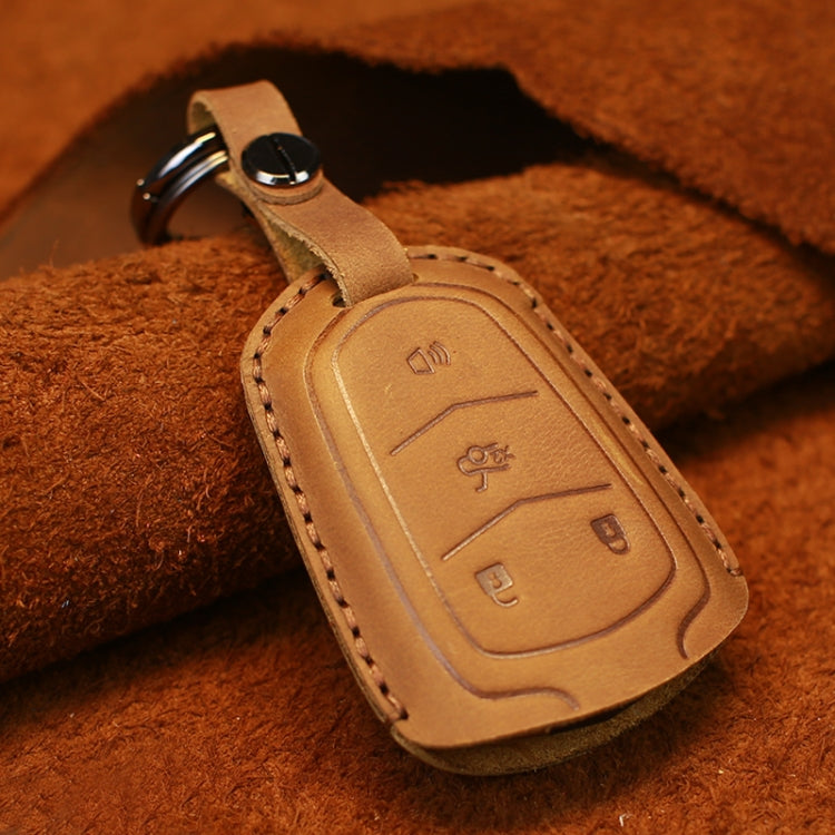 Tan leather key fob cover with embossed buttons, red-stitched edge and key ring