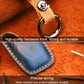 Blue leather key fob cover detail with metal key ring and tan strap
