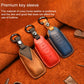 Leather key fob covers with keyrings in blue, red, and brown, stitched edges