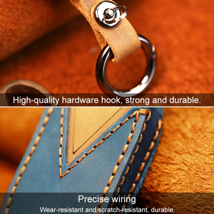 Leather key fob cover with tan strap and metal key ring, close-up view