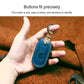 Blue leather key fob protective cover held in hand, tan strap and metal ring