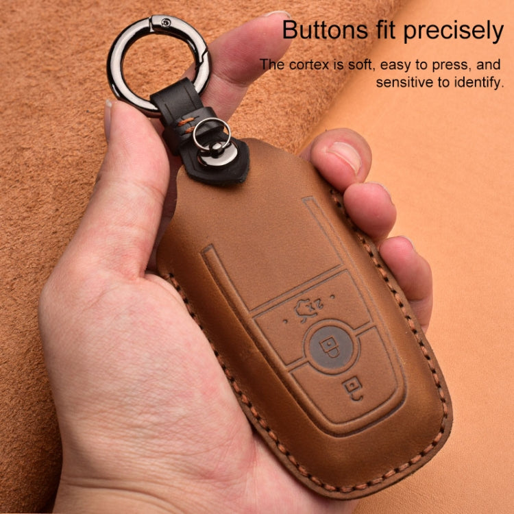 Brown leather key fob protective case with metal key ring, held in hands