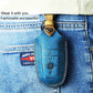 Blue leather key fob cover on denim jeans with metal key ring