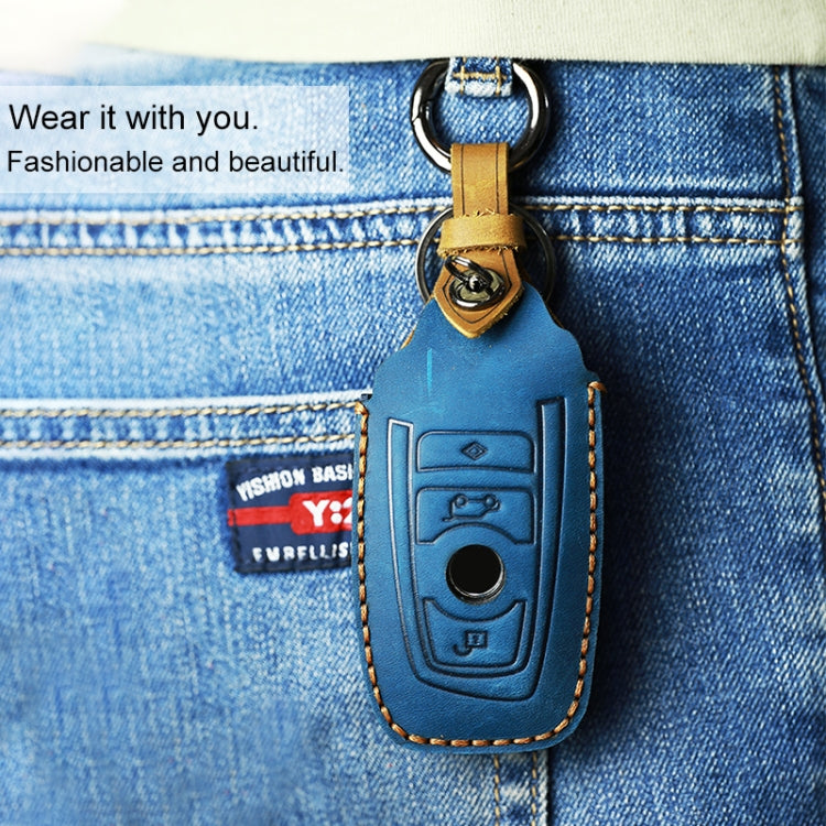 Blue leather key cover case with key ring attached to denim