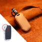 Beige leather key cover with metal ring, side strap, and stitched edges