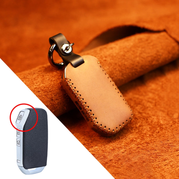Beige leather key cover with metal ring, side strap, and stitched edges