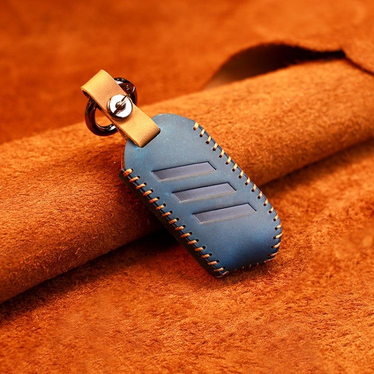Blue round leather key case cover with key ring, snap strap, and stitched trim