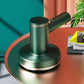 Green handheld cordless vacuum on round charging base with angled nozzle canister