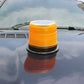 Orange round solar warning light on car dashboard with black base