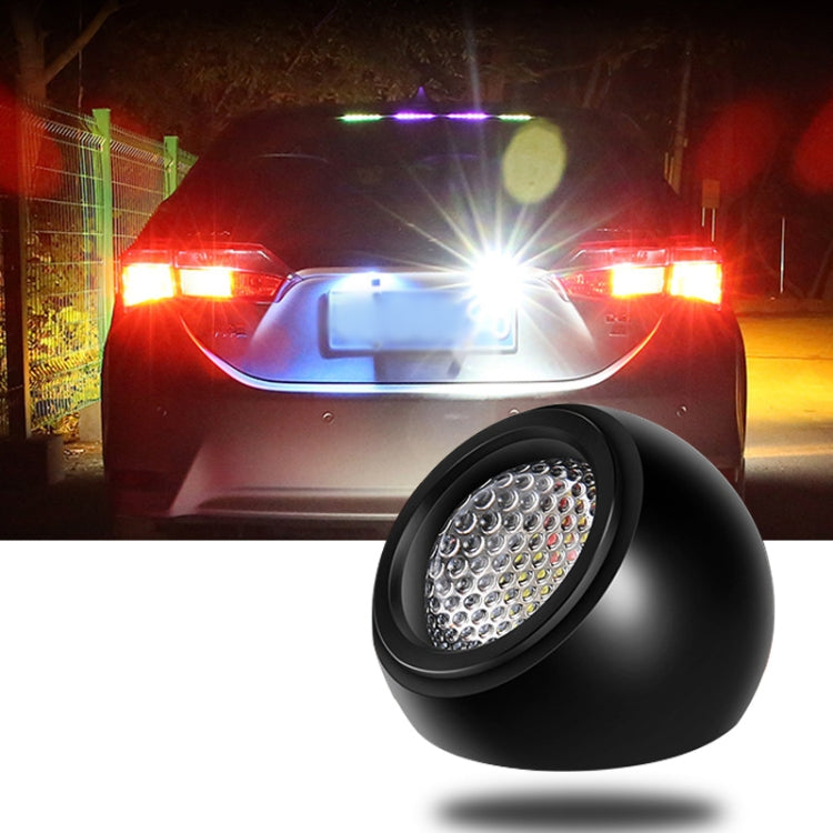 Round black LED reversing light with bright circular lens, shown near a car bumper