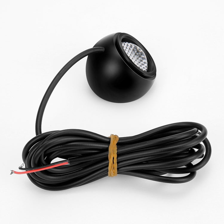 Black round LED reversing light with attached wire harness and connector terminals