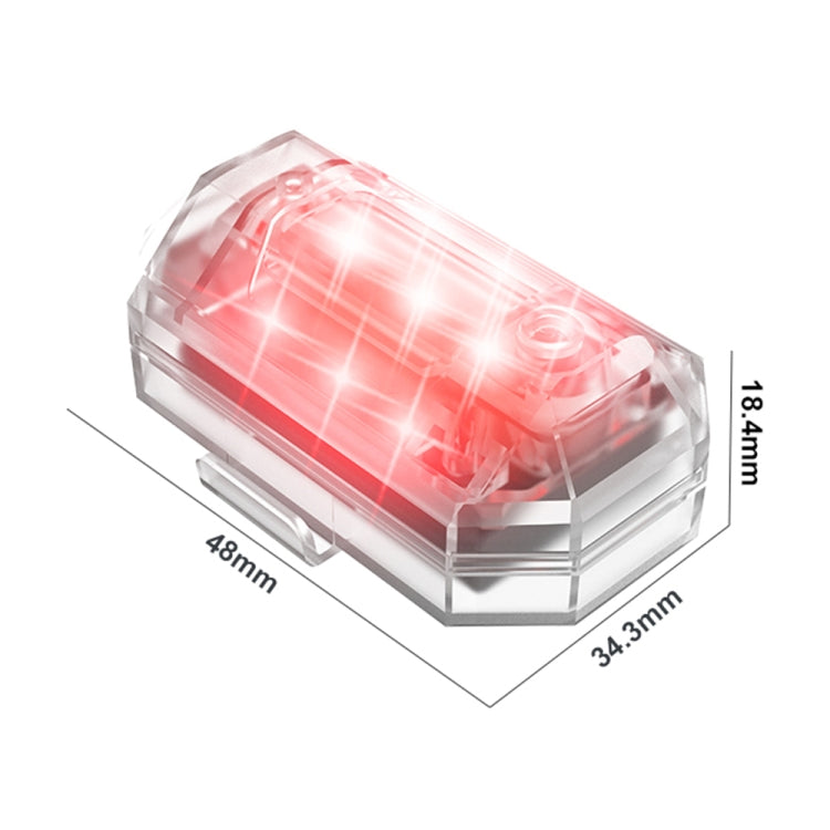 Motorcycle strobe light with red lens, clear body, angled side view