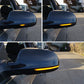 Car side mirrors with amber LED turn signal lights illuminated on both mirrors.