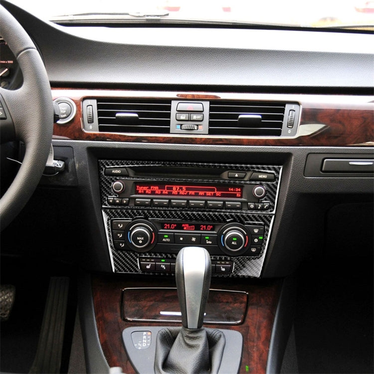 Carbon fiber CD panel trim sticker for BMW center console, installed over audio controls