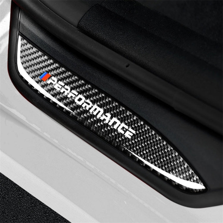 Close-up carbon fiber door sill sticker showing 'Performance' logo and blue-red emblem.