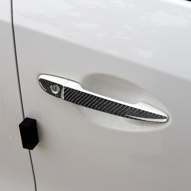 Carbon fiber outside door handle cover on a white car door, right side