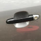 Exterior door handle installed on car door, dark gray/black with metal insert