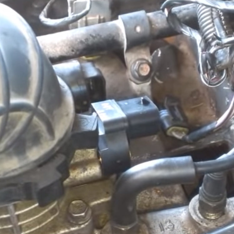 Throttle body position sensor mounted in engine bay near throttle housing
