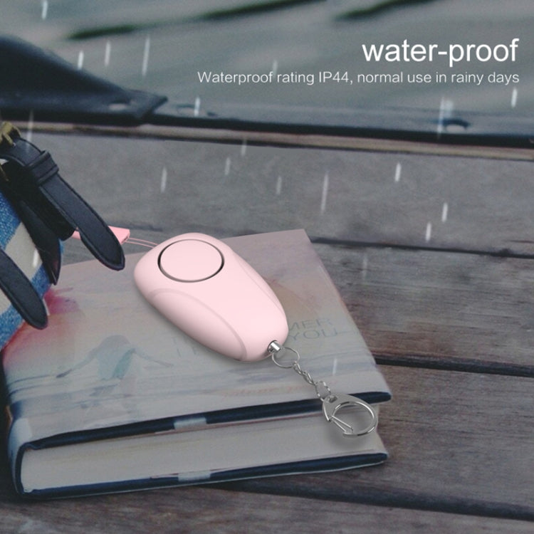 Pink waterproof personal alarm siren with keychain on a notebook, rain setting