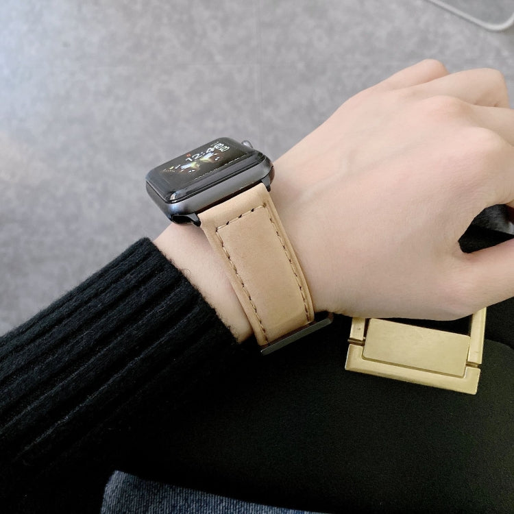 Beige leather buckle watch band on a wrist with stitched perforated strap