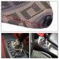 Black patterned shift knob dust cover with red trim and round opening at the top