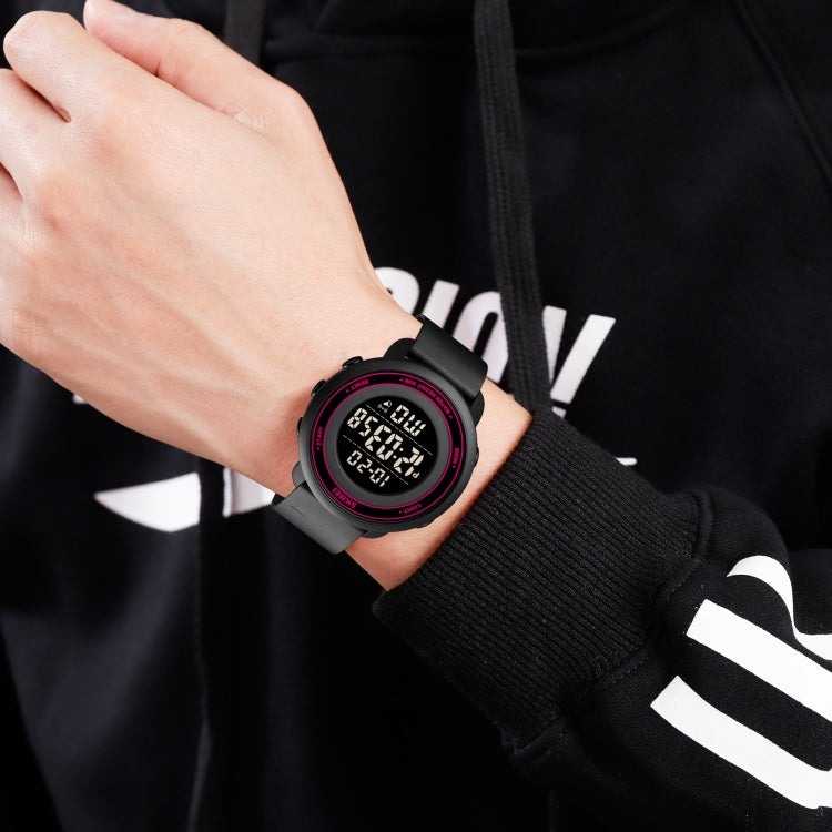 Round LED digital watch on wrist, black strap, red-accent bezel, glowing digits