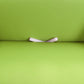 Lime green sofa cover with visible white anti-slip strap detail underneath