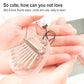 Mini 8-tone clear acrylic kalimba on a keychain, held in hands