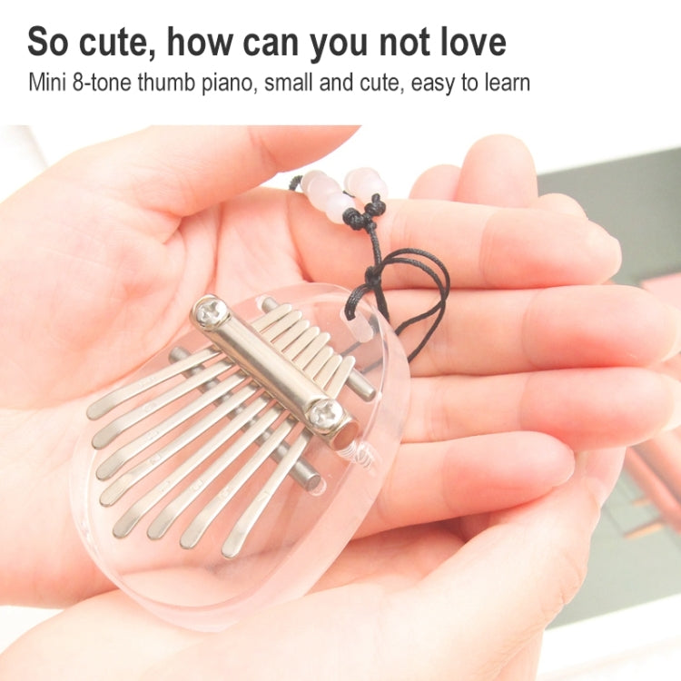 Mini 8-tone clear acrylic kalimba on a keychain, held in hands