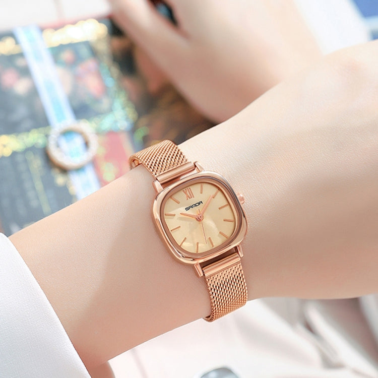Women’s quartz watch with rose gold mesh bracelet and cream dial on wrist