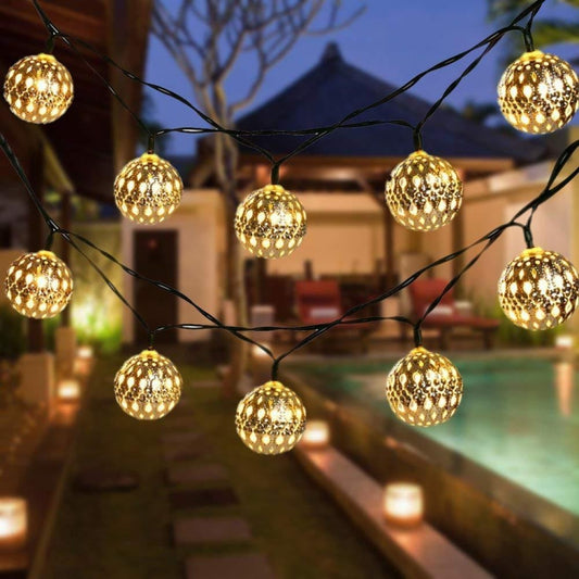 Gold hollow ball LED light string with round bulbs on black wire, outdoor garden style