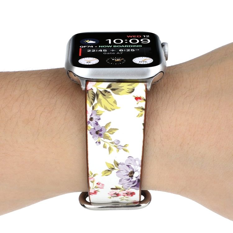 Floral watch strap with white rose and leaf print, brown leather underside, metal clasp.
