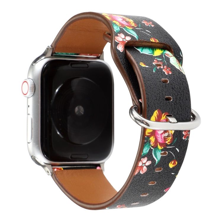 Floral watch strap with black background and colorful flowers, brown leather underside, metal clasp.