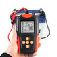 Car battery tester held in hand with clamp wires connected and LCD readout on screen