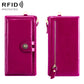 Magenta leather wallet with snap strap and gold zipper; side view.