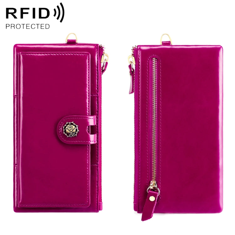 Magenta leather wallet with snap strap and gold zipper; side view.