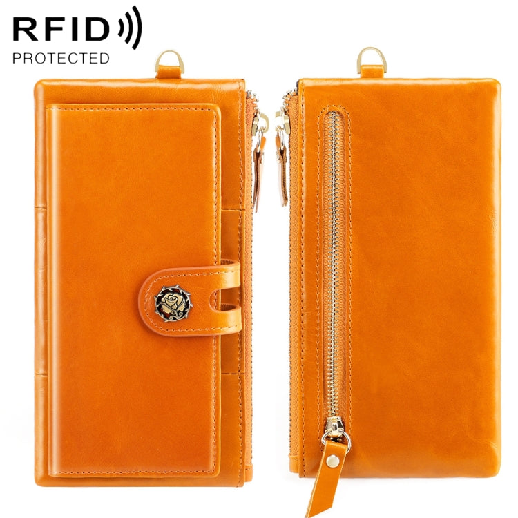 Orange oil-wax wallet with snap button strap and gold zipper; wrist strap loop.