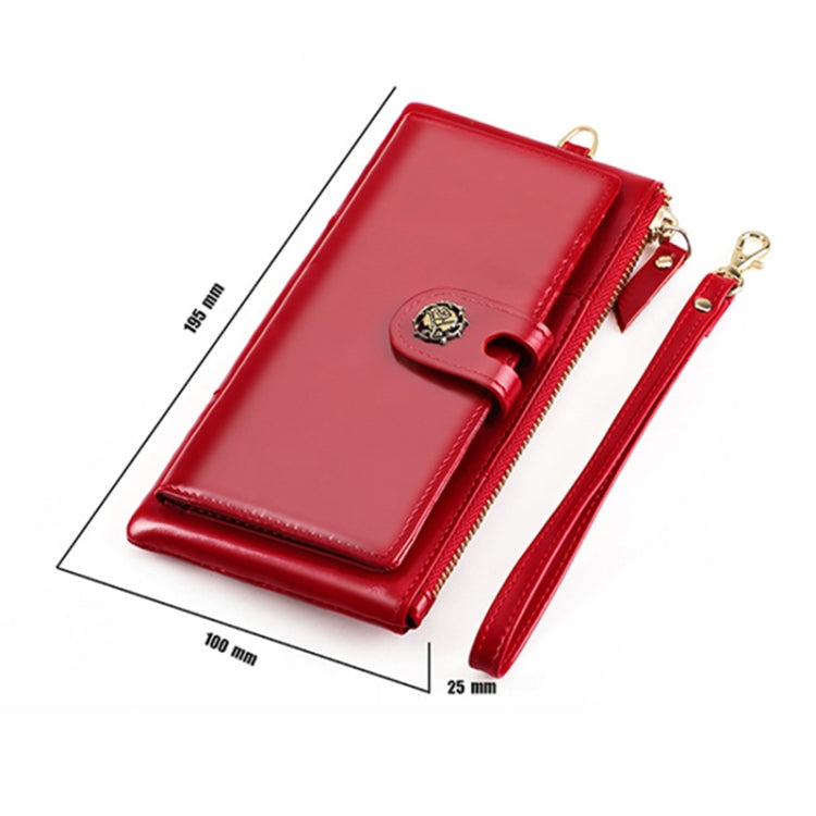 Red leather wallet with snap strap and gold zipper; wrist strap, angled view.