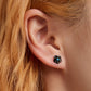 Black rose ear stud on model with blue gemstone center