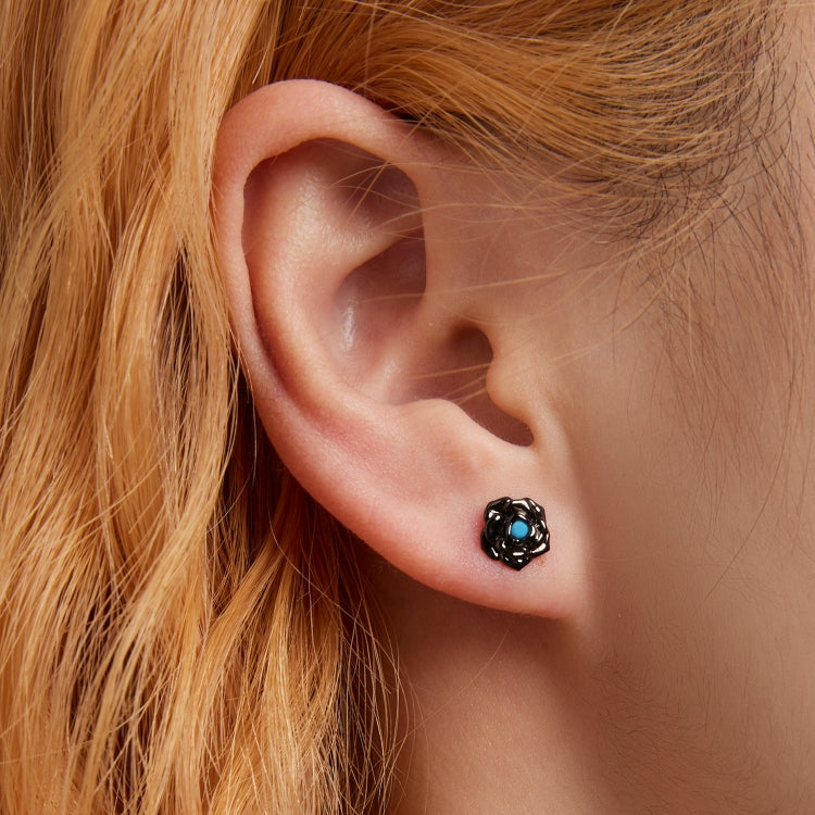 Black rose ear stud on model with blue gemstone center