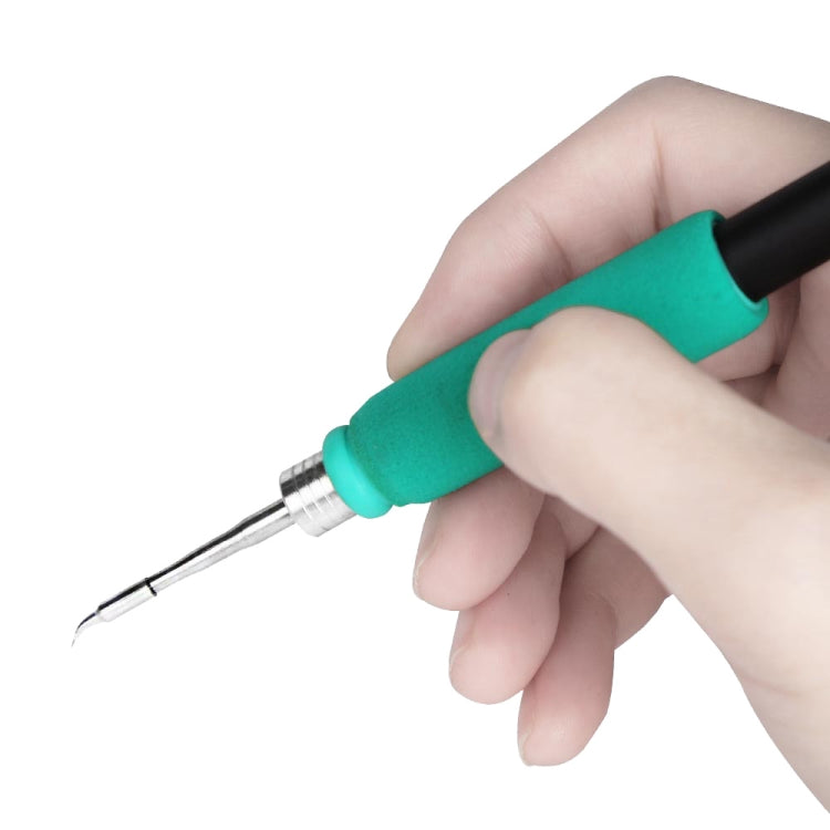 Soldering iron with teal grip, metal tip held close-up
