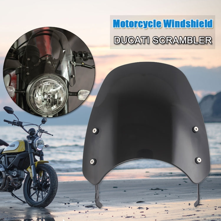 Dark motorcycle windshield with front mounting holes and curved visor