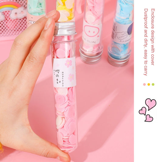 Pink tube-shaped mini soap with heart-shaped soap pieces, held in a hand