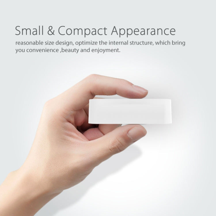 Compact white door sensor module held in a hand