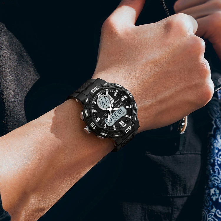 Black dual display digital watch on wrist with rubber strap and rugged bezel