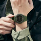 Green digital luminous watch on wrist with dark LCD and ribbed silicone strap