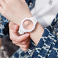 Waterproof sports electronic watch with rose dial and white strap, wrist close-up