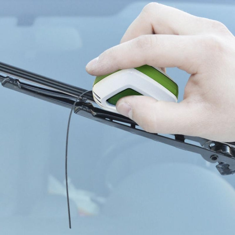 Hand sliding green-and-white wiper blade restorer over the wiper edge