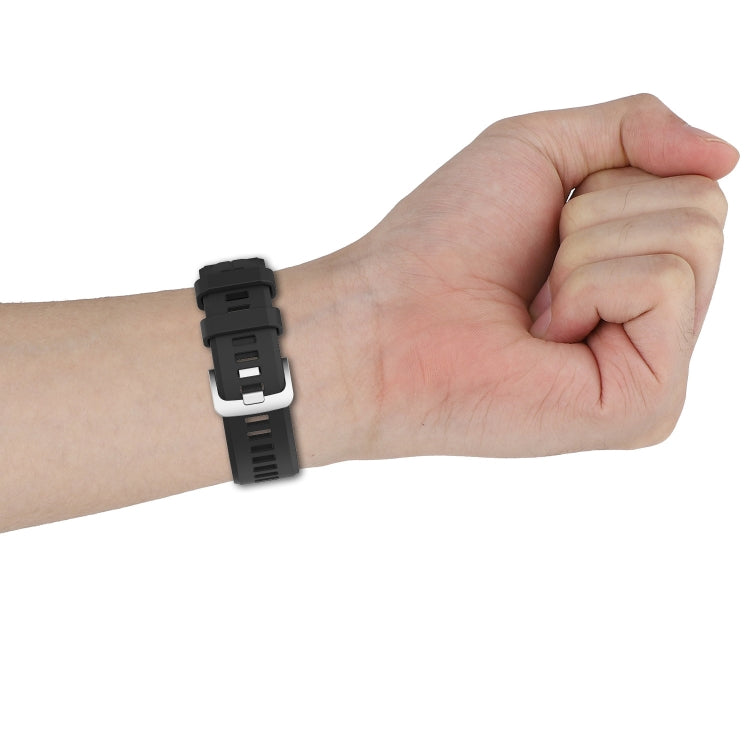 Black silicone watch band on wrist with adjustable buckle