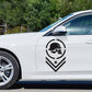 Skull-pattern emblem sticker close-up, black circular logo with helmeted skulls and chevrons
